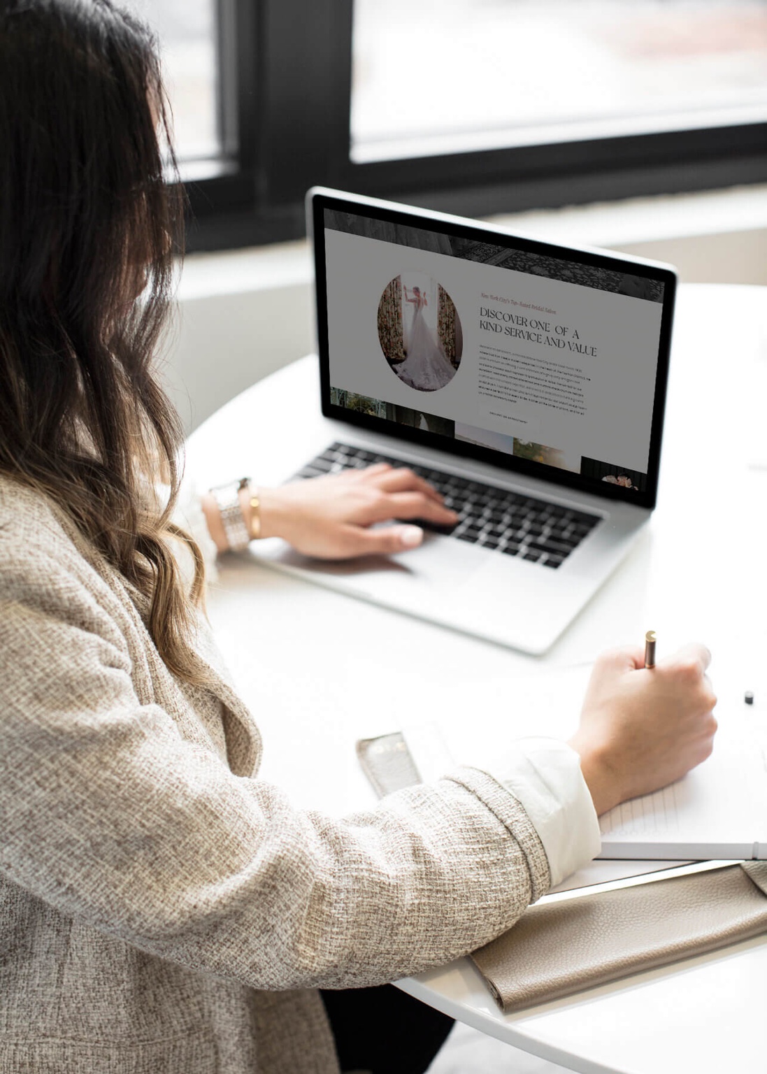 Woman entrepreneur working on a laptop, designing a website in a modern office setting.