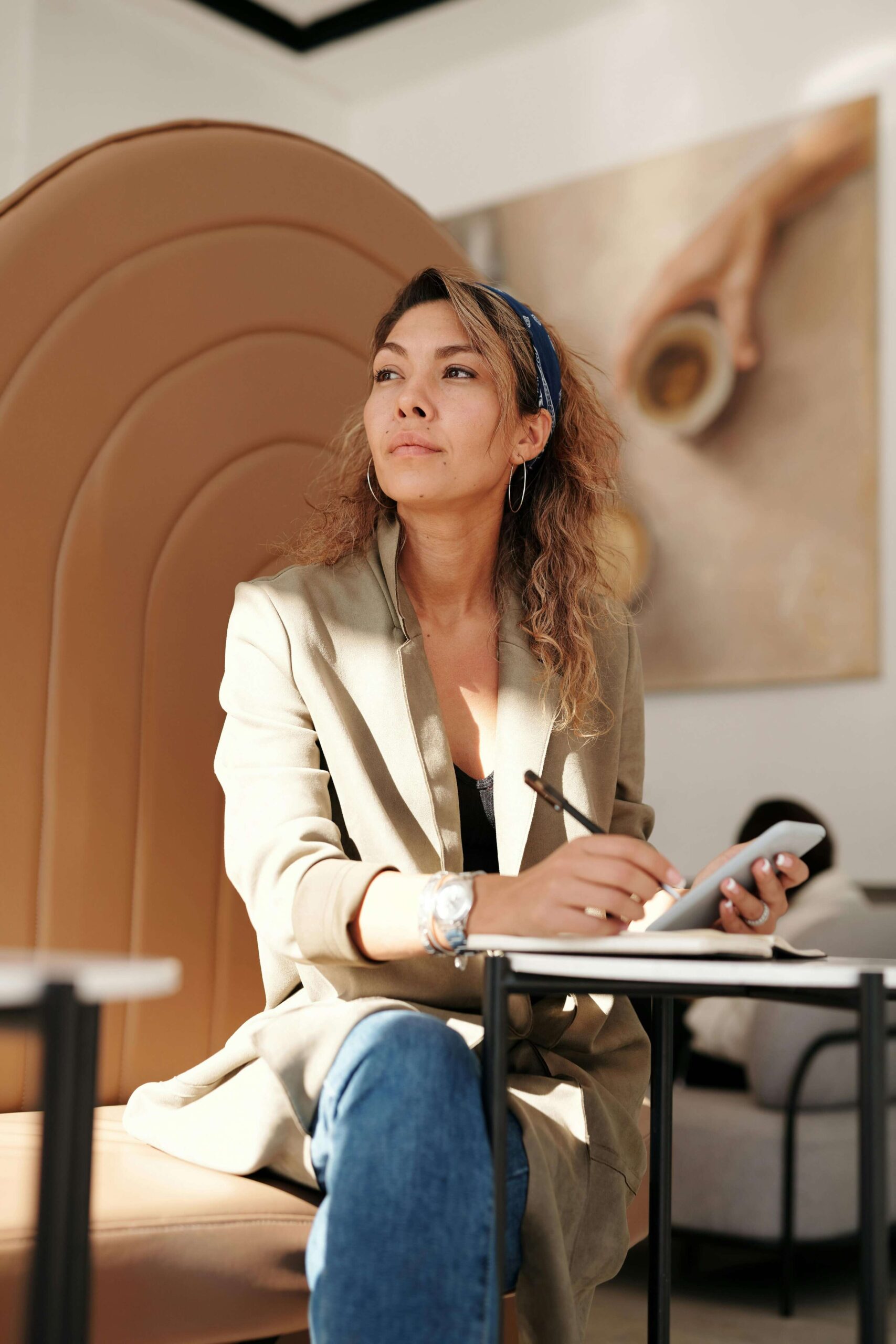 A thoughtful female entrepreneur taking notes in a professional setting, symbolizing resilience and determination.