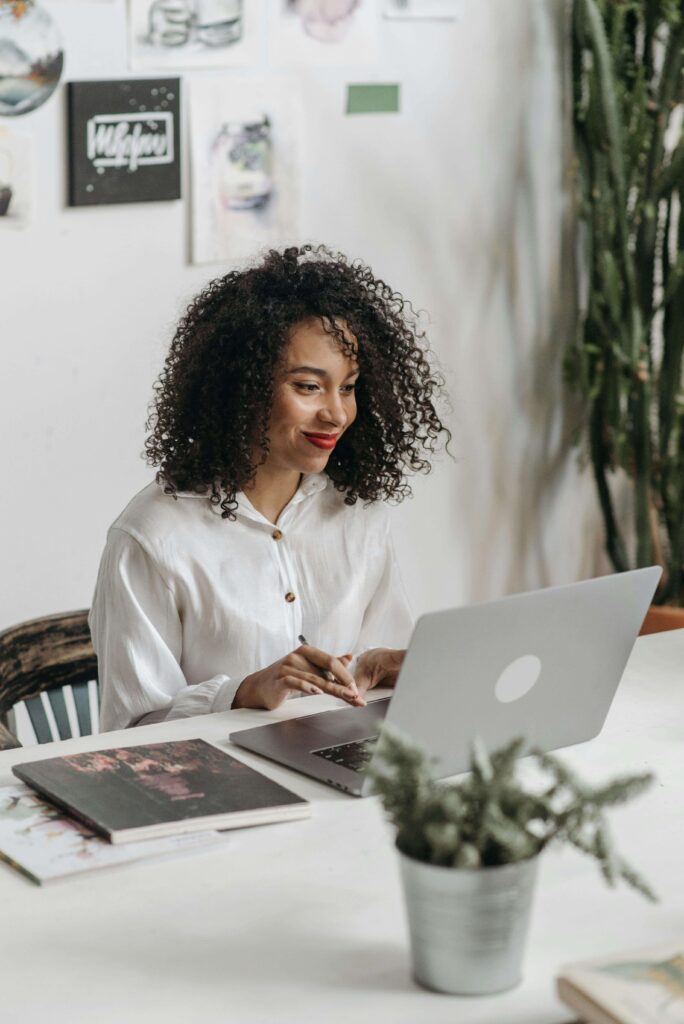 A woman reviewing brand colors and planning tools at her desk, capturing the clarity that comes from using essential tools for creative entrepreneurs.