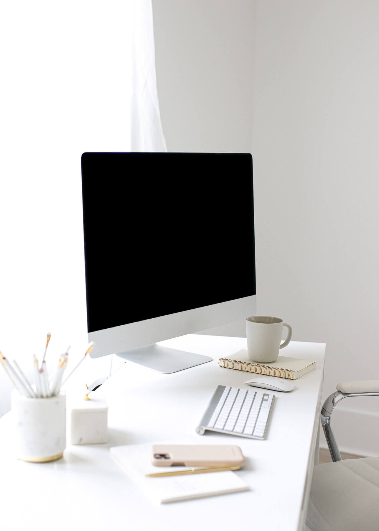 Clean, modern workspace with a desktop computer and coffee mug—capturing the fresh start of a website redesign.